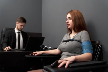 Yalan testi sırasında sandalyede oturan endişeli kadın