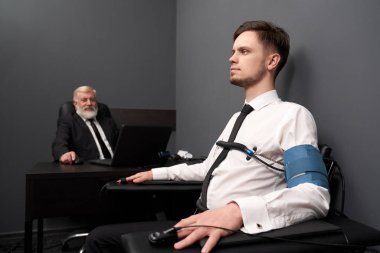 Dedektör üzerinde yalan testi sırasında doğruyu söyleyen ciddi adam