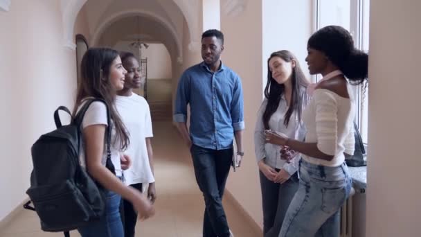 Africano e caucasiano meninas dizendo adeus aos amigos na faculdade — Vídeo de Stock