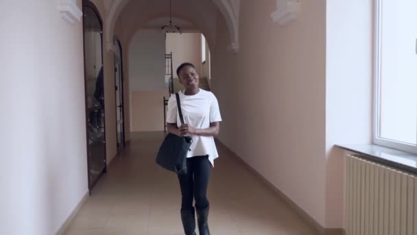 Front view of african student going in corridor after lesson — Stock Video