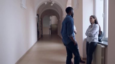 Üniversitede konuşan ve veda diyen üç öğrenci