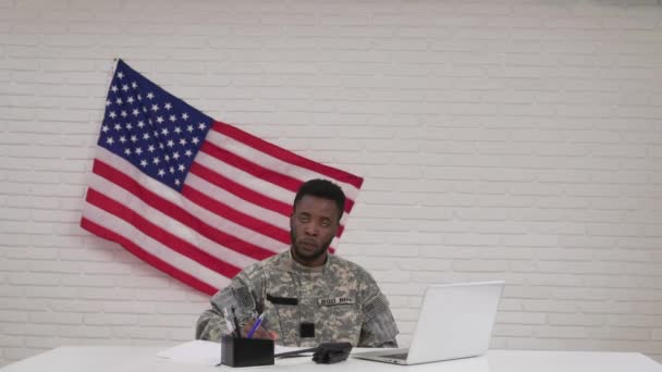 Afro-Amerikaanse mannelijke soldaat in camouflage zittend in kantoor — Stockvideo