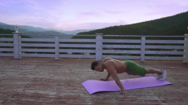 Çıplak gövde ile kas genç adam kol için egzersiz yapıyor