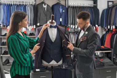 Shop danışman ve adam seçim takım, manken bakıyor.