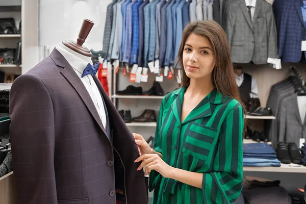 Consultora posando com jaqueta masculina, trabalhando na loja . — Fotografia de Stock