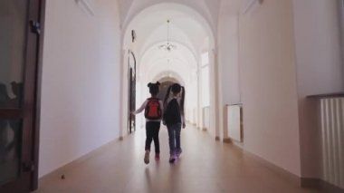 Sırt çantaları ile iki küçük arkadaş ders için birlikte gidiyor