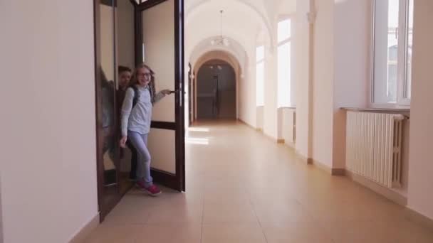 Happy children opening door and running through corridor — Stock Video