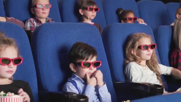 Niños felices viendo dibujos animados divertidos 3d en el cine moderno — Vídeo de stock