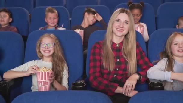 Female teacher with group of children attending cinema — Stock Video