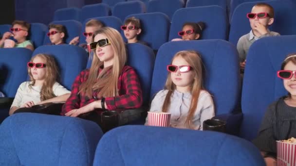 Современное кино с детьми, смотрящими мультфильм в 3D очках — стоковое видео