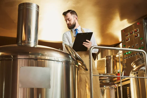 El hombre controla el proceso de fabricación de cerveza — Foto de Stock