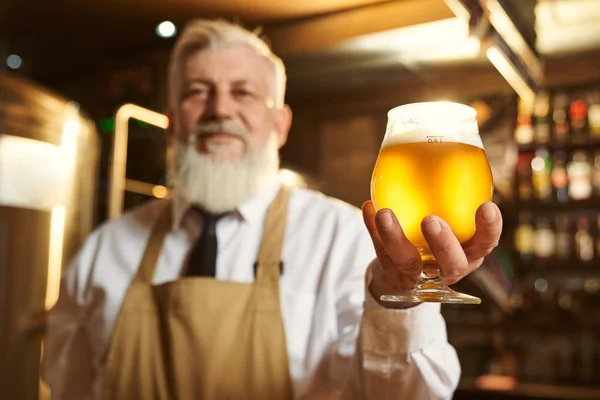 노인의 손에 가벼운 맥주 한 잔의 선택적 초점 — 스톡 사진