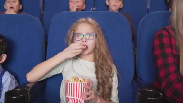 Група досить маленьких глядачів, які відвідують кінотеатр разом — стокове відео