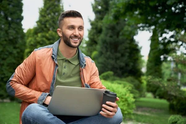 Freelancer trabalhando no laptop no jardim verde . — Fotografia de Stock