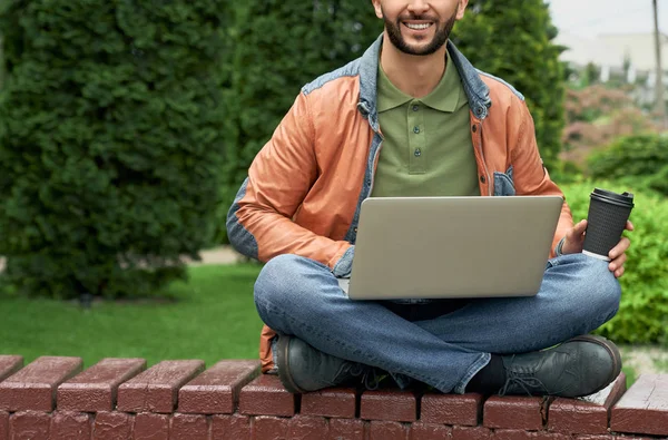 Freelancer alegre sentado com laptop com pernas cruzadas . — Fotografia de Stock