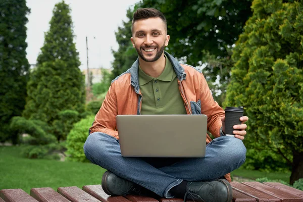 Freelancer alegre com laptop e xícara de café . — Fotografia de Stock