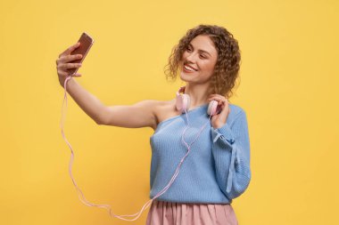 Güzel model pembe kulaklık ve telefon ile poz.