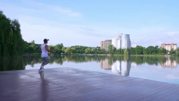 Zdravě mladý sportovec, trénink s lanem blízko městského jezera — Stock video
