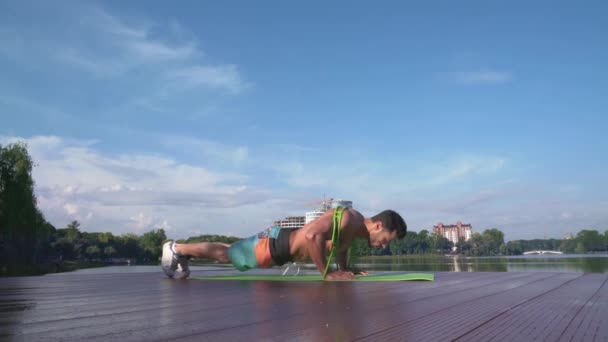 Fiatal atlétikai férfi meztelen felsőtesttel fekvőtámasz gyakorlatokat végez — Stock videók