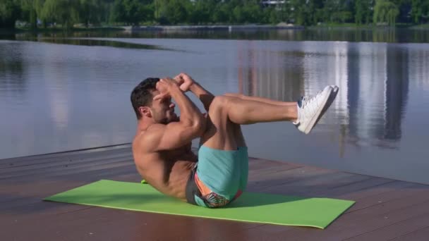 Shirtless sportman liggend op groene yoga mat en oefenen — Stockvideo