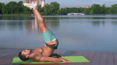 Üstsüz adam bacakları kaldırarak alt abs egzersiz yapıyor