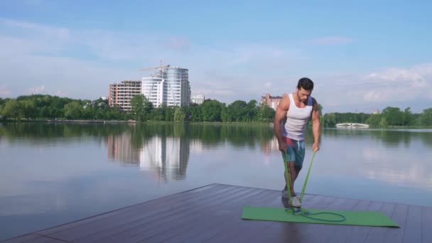 Aktiv Sportsman i sport kläder tränings armar nära sjön — Stockvideo