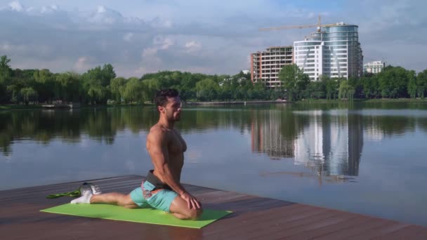 Jonge knappe sportman die lichaams activiteit doet op de pier van het meer — Stockvideo