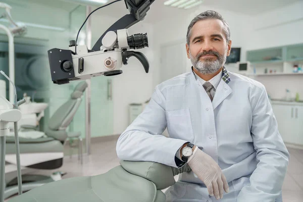 Professzionális férfi fogorvos látszó-on fényképezőgép, és mosolyogva — Stock Fotó
