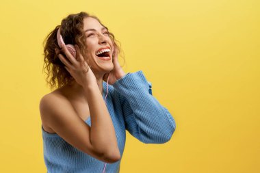 Mavi bluzlu komik bir model kulaklıklı müzik dinliyor..