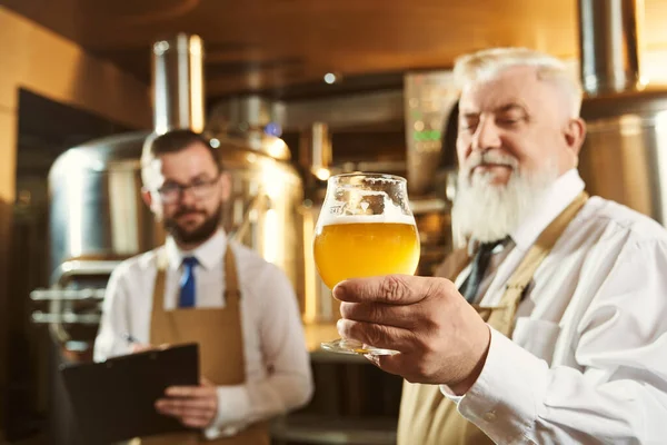 Esperti che esaminano birra in fabbrica . — Foto Stock