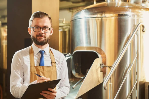 Experto de la cervecería que sostiene la carpeta, posando, mirando a la cámara . — Foto de Stock