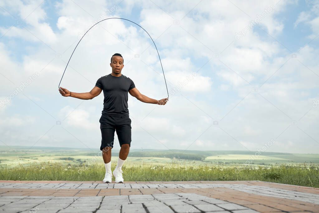 Athlete training with jumping rope outdoors.