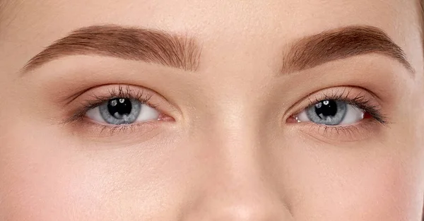 A női kék szemek és a tökéletes szemöldök közelsége — Stock Fotó