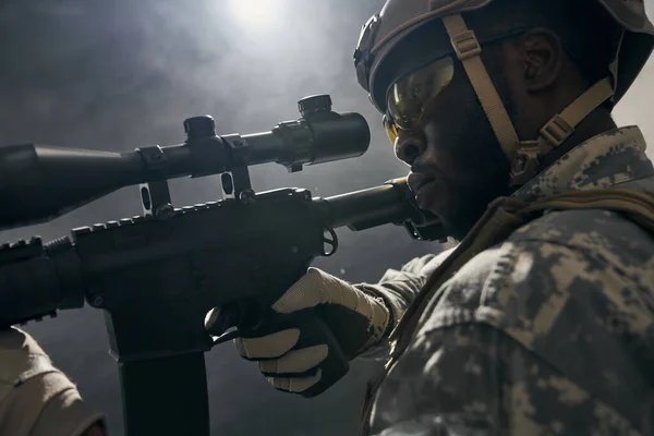 Közelkép az amerikai katonáról, aki szemmel tartja a modern fegyvert.. — Stock Fotó