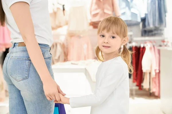Söt liten flicka i boutique hålla hand med mamma, poserar. — Stockfoto