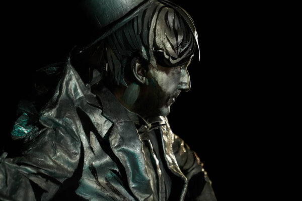 Side view of mime actor with facial makeup looks like statue