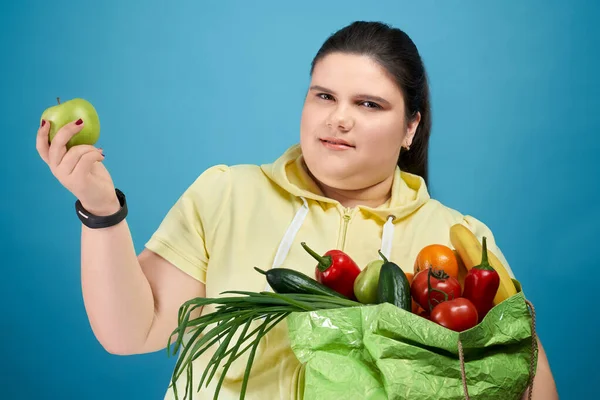 Klobige Mädchen halten Paket mit Obst und Gemüse — Stockfoto