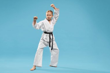 Siyah kuşaklı, karate antrenmanı yapan kimonolu bir kız..