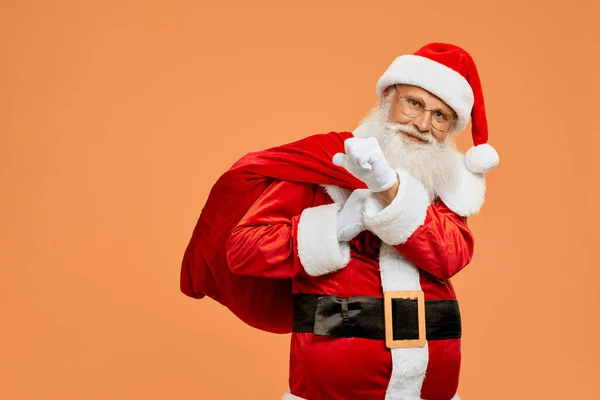 Szczęśliwy Święty Mikołaj niosąc na duży czerwony worek pełen prezentów — Zdjęcie stockowe