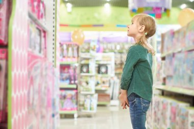 Küçük bir dükkan müşterisi oyuncaklarla kendine bakıyor..