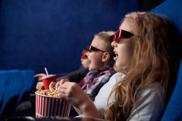 Shocked girl with friends watching film in movie house — Stock Photo, Image