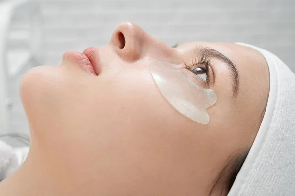 Mujer con almohadillas de colágeno bajo los ojos para el rejuvenecimiento . — Foto de Stock