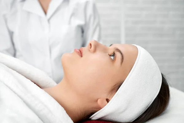 Cliente femenino del centro de cosmetología acostado en la mesa de masaje . — Foto de Stock