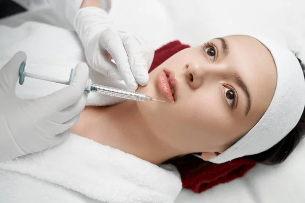 Manos del cosmetólogo haciendo la inyección de labios . — Foto de Stock