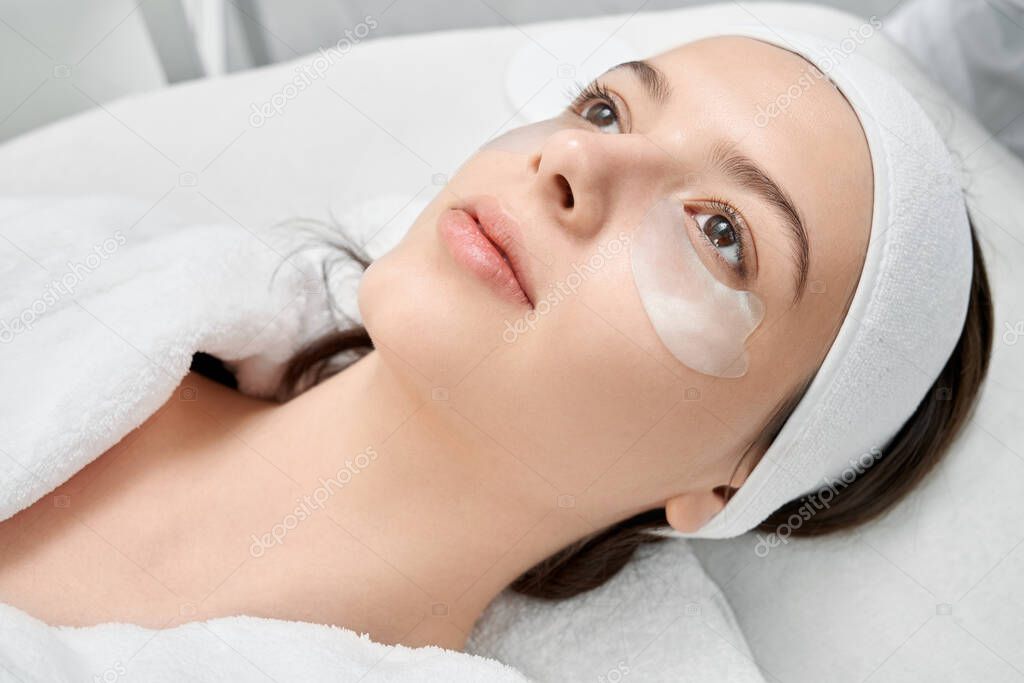 Woman application patches with collagen for skin care.