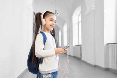 Ders arasında molada olan kız koridorda müzik dinliyor..