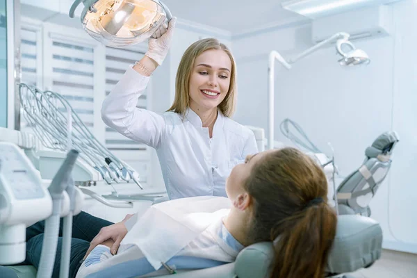 Arzt betrachtet Klientin im Zahnarztstuhl liegend. — Stockfoto