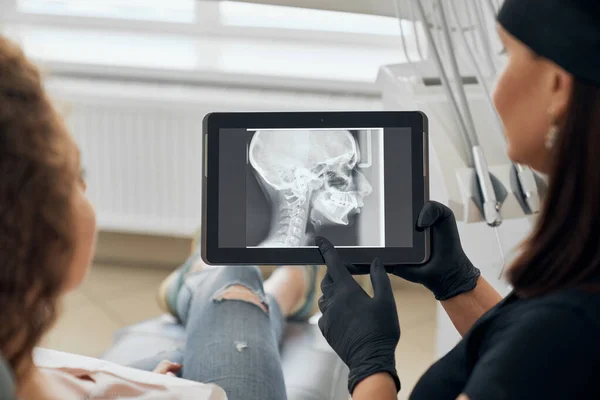 Таблетка с рентгеновским снимком челюсти в руках стоматолога — стоковое фото