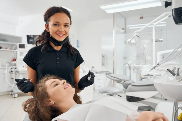 治疗牙齿时女牙医姿势的前景 — 图库照片