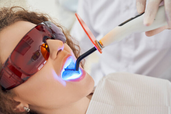 Male dentist keeping ultraviolet tool